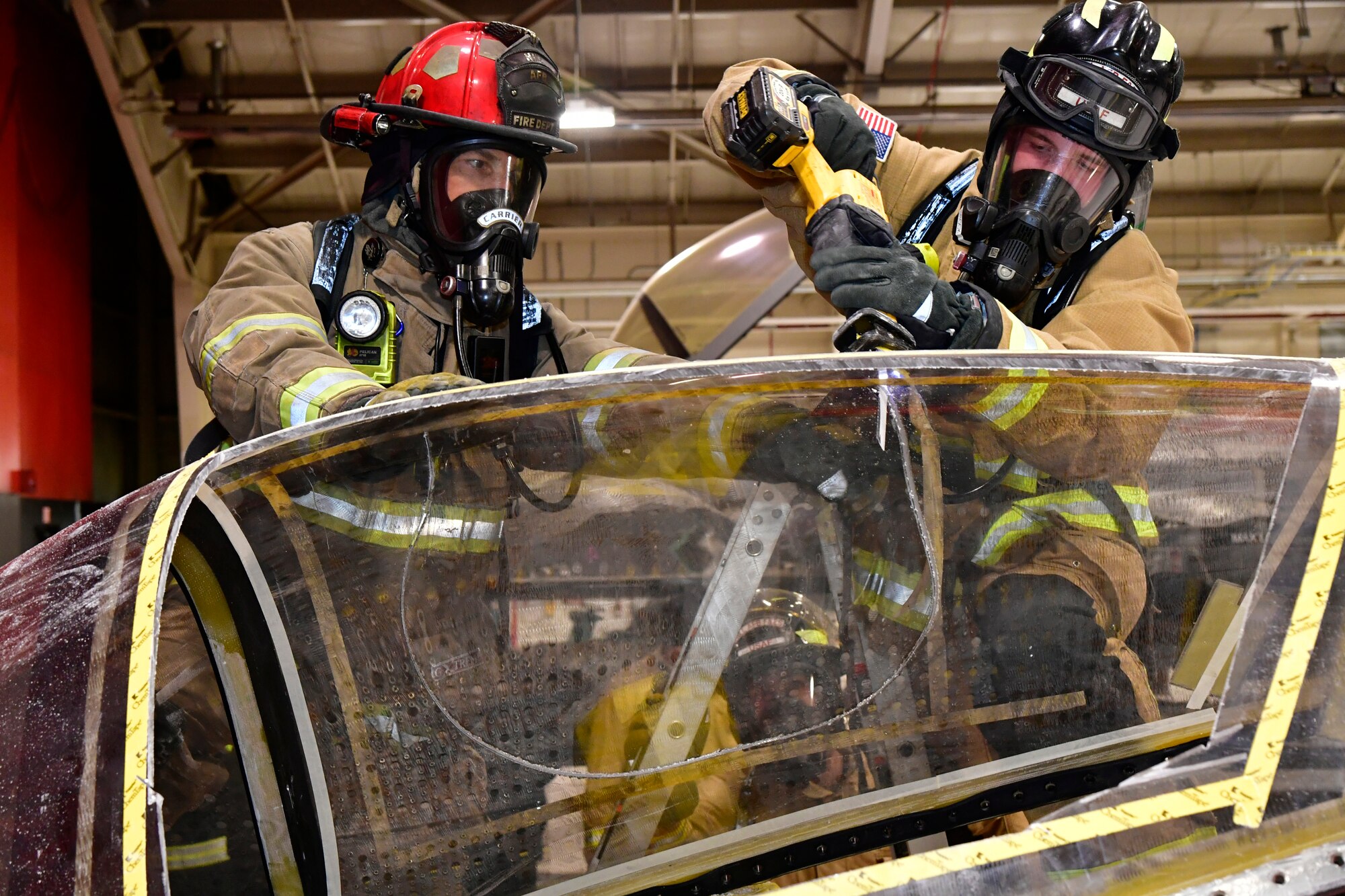 (Left to right) Chad Carrier, lead firefighter, and Airman 1st Class Joseph Brock, fire protection apprentice, both with 775th Civil Engineering Squadron Fire Department, practice cutting into a salvaged canopy for the purpose of emergency aircrew extraction Jan. 24, 2023, at Hill Air Force Base, Utah. This was one of several scenarios practiced during an emergency responder working group exercise attended by first responders from across the Air Force to explore emergency engine shutdown and aircrew extraction best practices specific to F-35 aircraft. (U.S. Air Force photo by Todd Cromar)