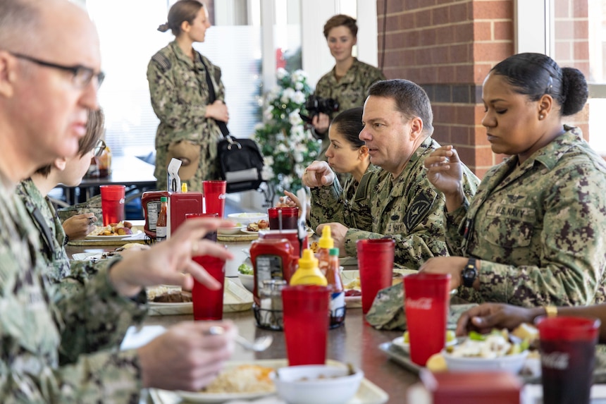 Chief of Naval Personnel Vice Adm. Rick Cheeseman, center, eats lunch with Sailors assigned to Naval Air Technical Training Center (NATTC) as part of a visit to Pensacola area Naval Education and Training Commands (NETC), Jan. 26, 2023. NETC's mission is to recruit, train and deliver those who serve our nation, taking them from street-to-fleet by transforming civilians into highly skilled, operational and combat ready warfighters. (United States Navy photo by Mass Communication Specialist 2nd Class Zachary Melvin)