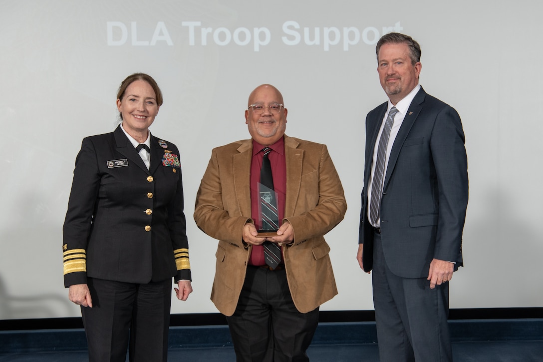 DLA Troop Support Equal Employment Opportunity and Diversity Director Carlos Deno, center, poses with DLA Director Navy Vice Adm. Michelle C. Skubic, left, and DLA Vice Director Brad Bunn, right, after receiving the Achievement in EEO by an Organization award during DLA's 55th Annual Employee Recognition Awards held Jan 26 at the McNamara Headquarters Complex on Fort Belvoir, Va.