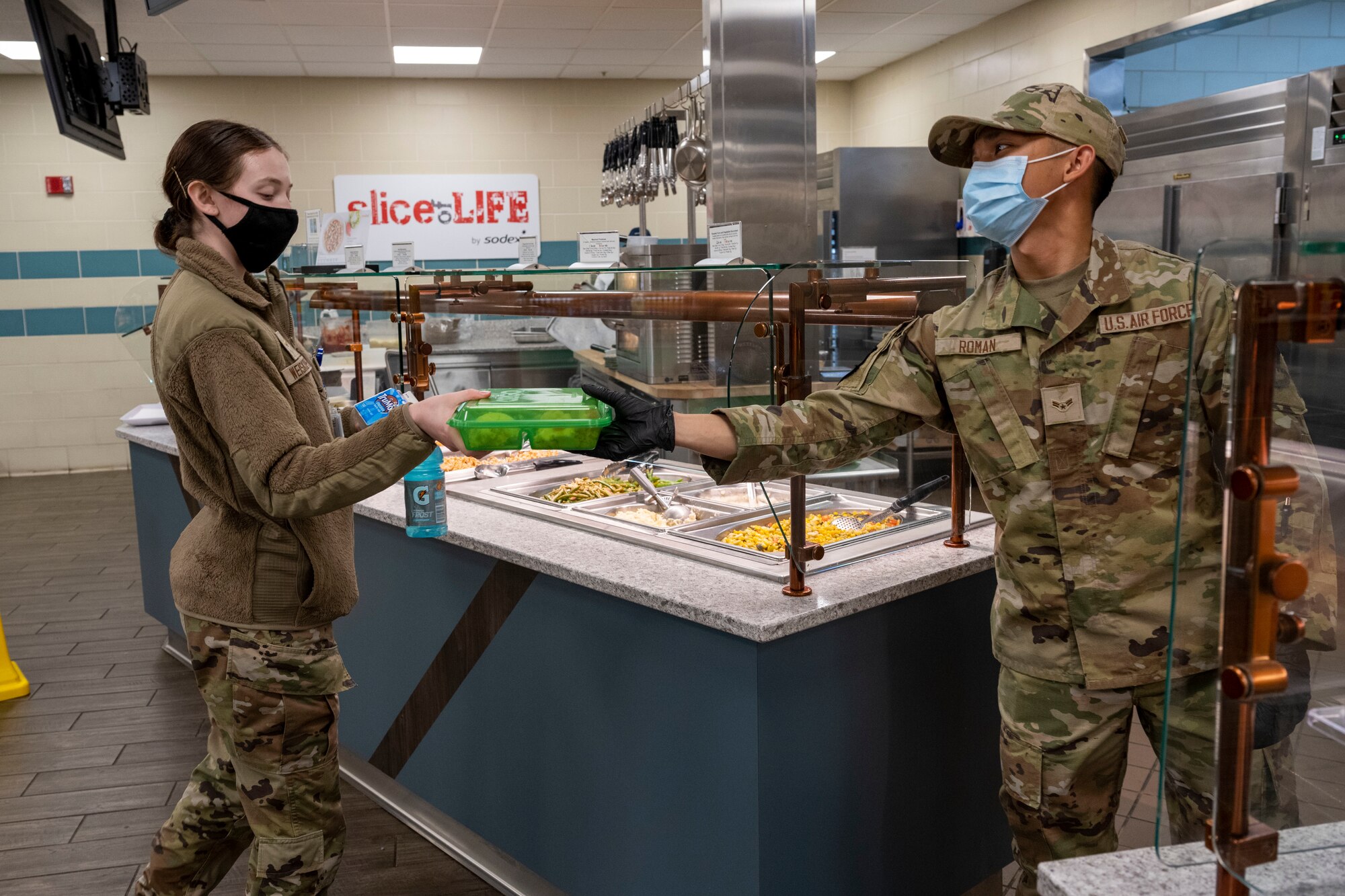 Airman 1st Class Hunter Pearson, 4th Force Support Squadron food service specialist, assembles a cheeseburger in an OZZI reusable food container at Seymour Johnson Air Force Base, North Carolina, Jan. 24, 2023. The OZZI food container is a replacement for previously used foam takeout containers to cut down on both costs and generated waste. (U.S. Air Force photo by Senior Airman Kevin Holloway)