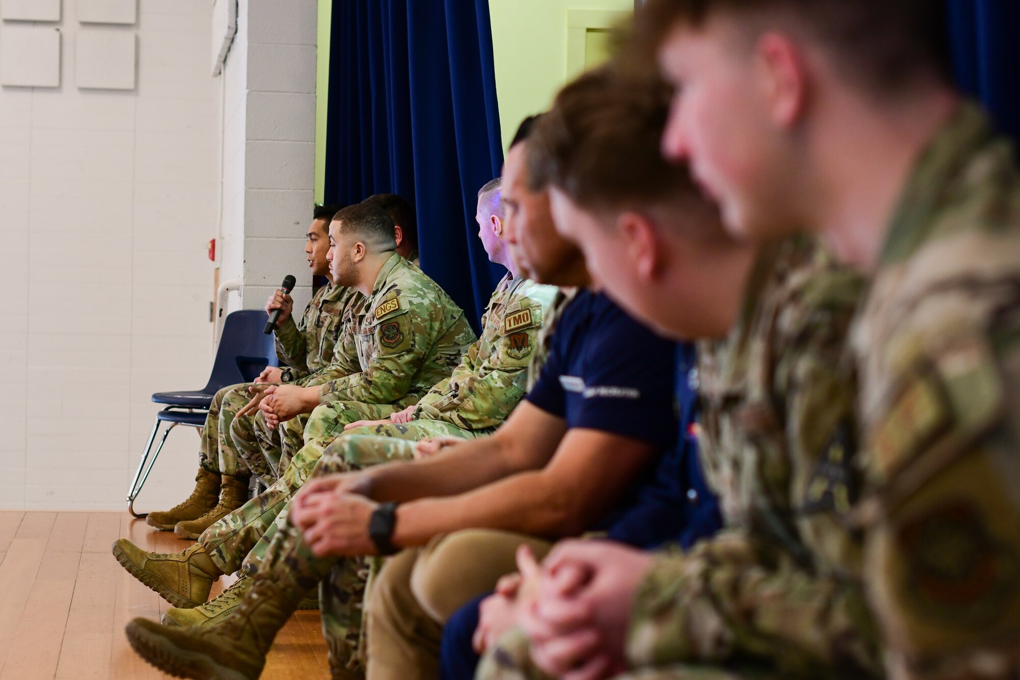 Military members sit on stage at Redwood Middle School in Napa, Calif., on Jan. 25, 2023.