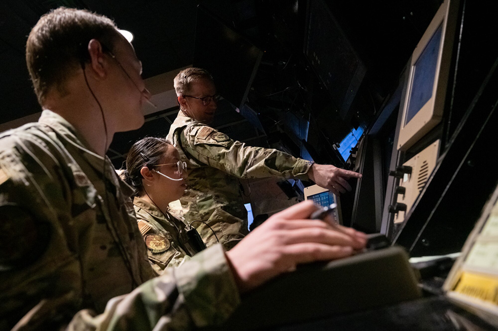 U.S. Air Force Senior Airmen Nicholas Anderson (left), Kristen McQueen (center), and Tyler Turnbull (right), 56th Operation Support Squadron radar approach control trainers, monitor flight paths, Jan. 27, 2023, at Luke Air Force Base, Arizona.