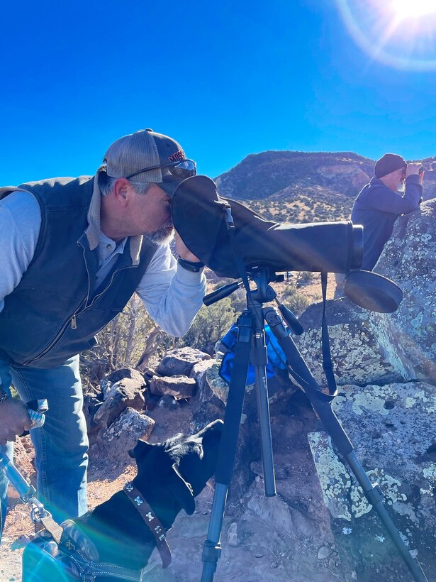 A volunteer, stationed on the Highway 96 Overlook, looks through a scope to spot eagles during the annual Midwinter Bald Eagle Watch and Survey event held at Abiquiu Lake, Jan. 7, 2023.