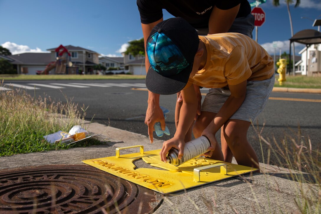 A volunteer applies a “No Dumping” sign during Operation Clean Water Ohana, Marine Corps Base Hawaii, Jan. 3, 2023. The purpose of Operation Clean Water Ohana is to protect resources and raise awareness of potential contaminants that wash down storm drains, ending up in the ocean. (U.S. Marine Corps photo by Lance Cpl. Clayton Baker)