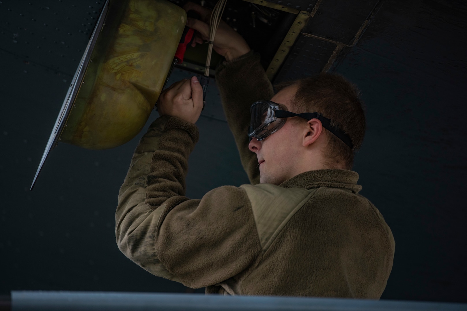 U.S. Air Force Senior Airman Kyle Sexton, 317th Aircraft Maintenance Squadron electrical environmental technician, wraps safety wire on a C-130J Super Hercules at Pope Army Airfield, North Carolina, Jan. 25, 2023. During Battalion Mass Tactical Week, Sexton completed aircraft maintenance, ensuring that each C-130 was mission capable. (U.S. Air Force photo by Airman 1st Class Ryan Hayman)