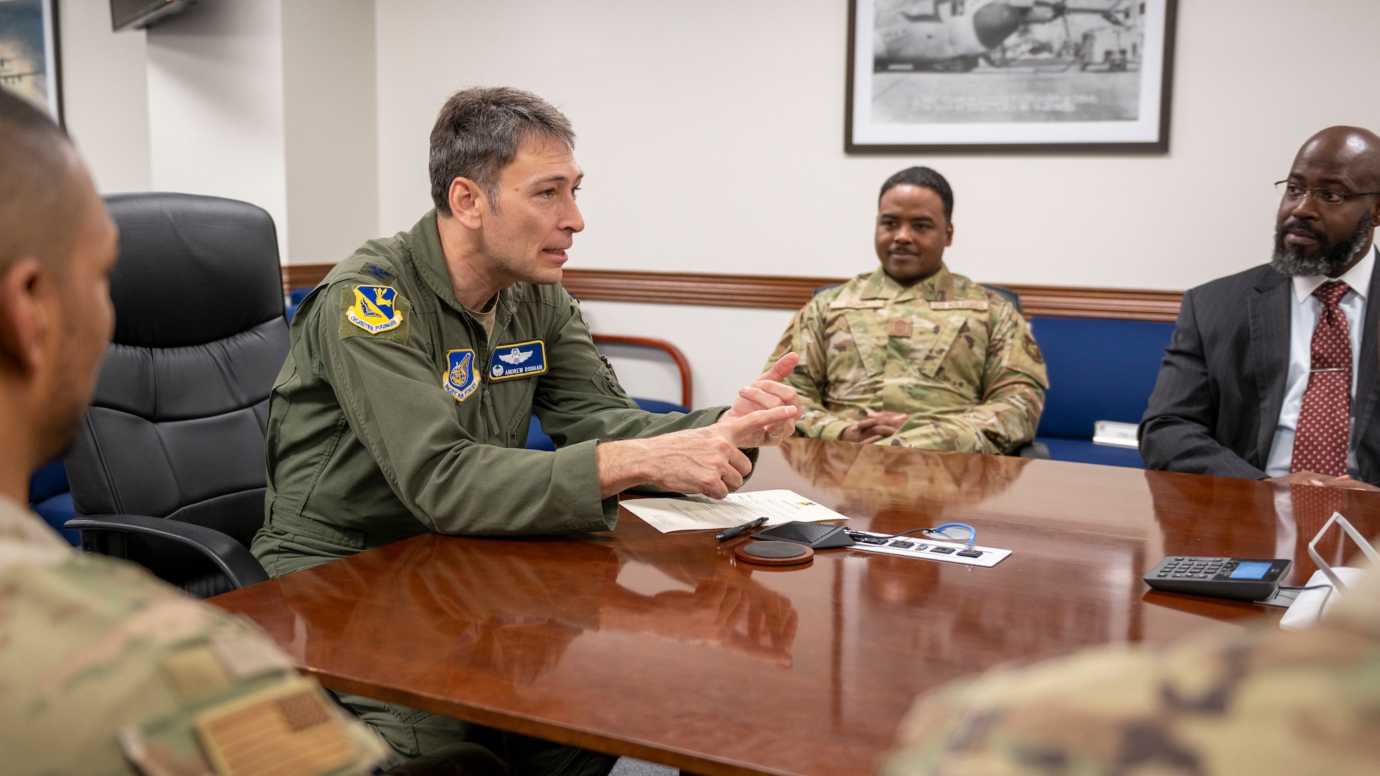 Commander speaks with representatives at a conference table