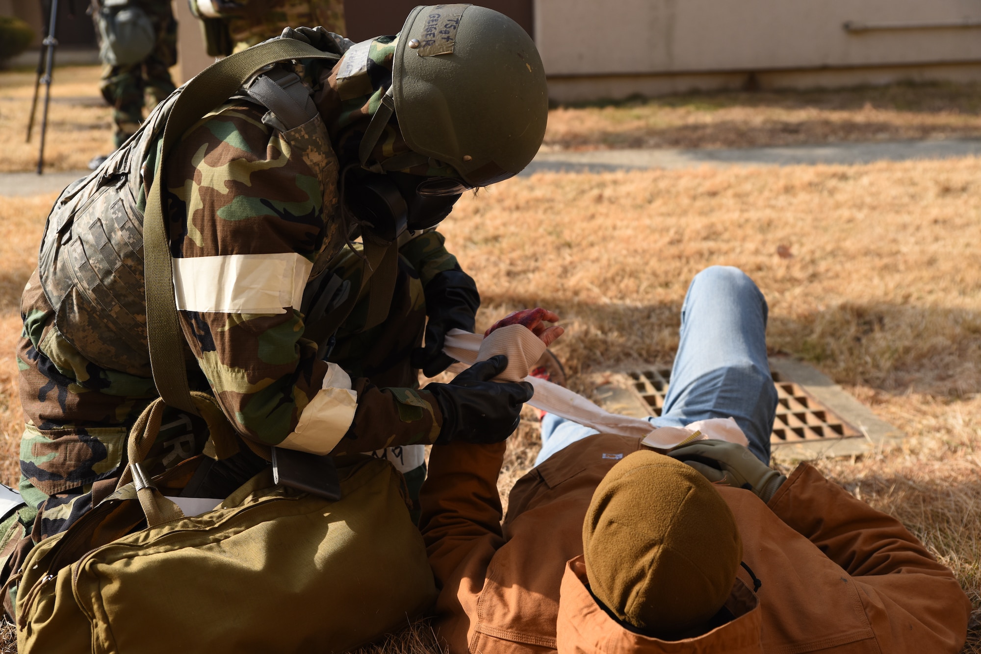 U.S. Air Force Tech Sgt. Cameron Geiger, Financial Management Flight customer service NCOIC from the 51st Comptroller Squadron, conducts tactical combat casualty care (TCCC) on a simulated trauma patient during a base-wide training event at Osan Air Base, Republic of Korea, Feb. 1, 2023. Airmen are trained to perform TCCC methods to stabilize trauma patients until medical personnel arrive. (U.S. Air Force photo by 1st Lt Michelle Chang)