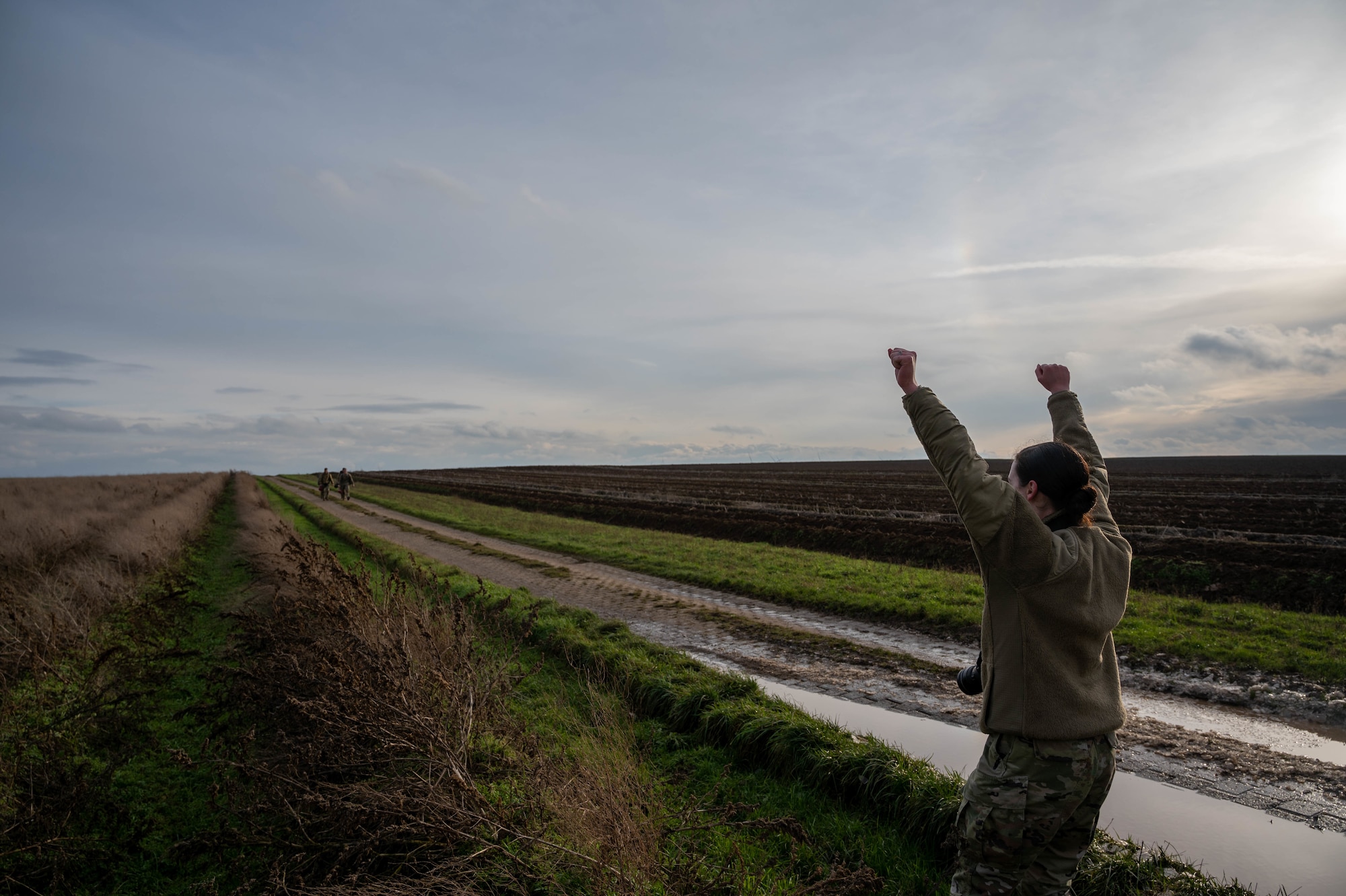 U.S. Air Force Airman 1st Class Kaitlyn Oiler, 86th Airlift Wing public affairs apprentice, cheers on paratroopers from the 435th Security Forces Squadron, including her husband, Staff Sgt. Matthew Oiler, 435th Contingency Response Group team chief, after a static line jump at Alzey Drop Zone in Ober-Flörsheim, Germany, Jan. 20, 2023. The Oilers have been married since 2018 and Airman 1st Class Oiler decided to enlist in 2021, six years after her husband enlisted. (U.S. Air Force photo by Staff Sgt. Branden Rae)