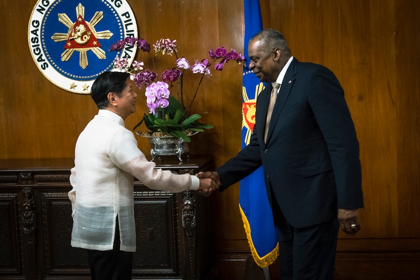 Two men shake hands.