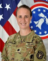 Female Soldier posed in front of the U.S. flag and the U.S. Army Recruiting Command flag