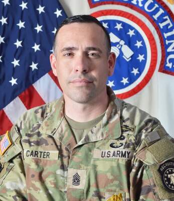 Male Soldier posed in front of the U.S. flag and the U.S. Army Recruiting Command flag.