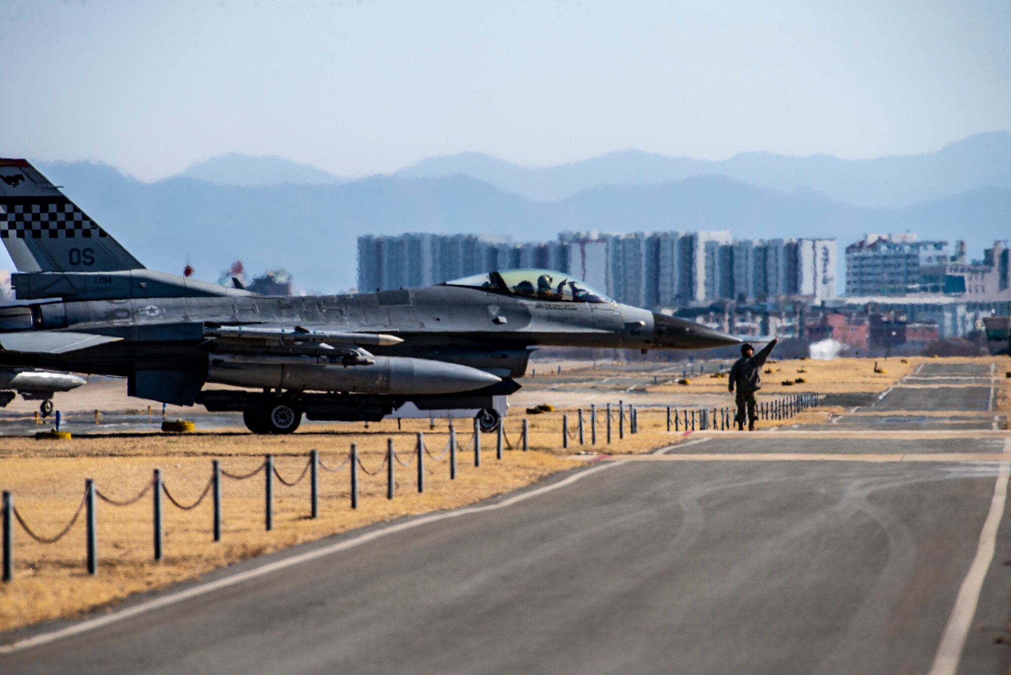 A U.S. Air Force Airman, 51st Fighter Wing, directs an F-16 Fighting Falcon during a routine training event at Daegu Air Base, Republic of Korea, Jan. 30, 2023.