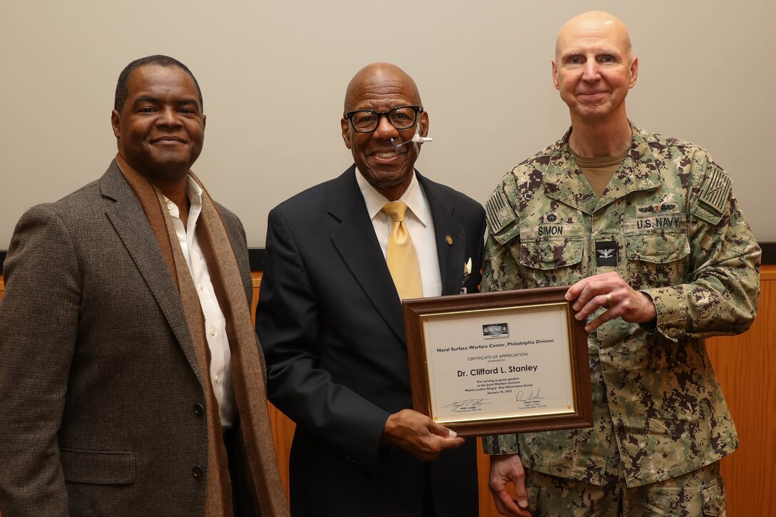 Naval Surface Warfare Center, Philadelphia Division Commanding Officer Capt. Dana Simon and Technical Director Nigel C. Thijs present retired U.S. Marine Corps Major General, the Honorable Dr. Clifford L. Stanley with a certificate of appreciation during the Naval Sea Systems Command Joint Warfare Centers’ Martin Luther King Jr. Day Observance hosted by NSWCPD on Jan. 19, 2023.  (U.S. Navy photo by Gary Ell, Ctr/Released)