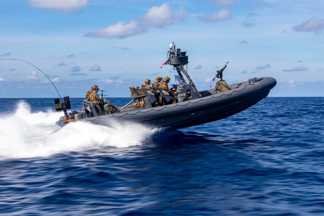Marines travel through waters in a small inflatable boat.