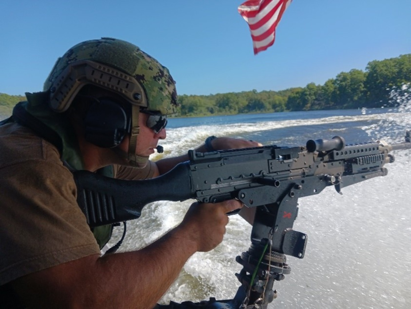 Petty Officer 2nd Class Nicholas Lusk, a PSU 309 tactical boat crew member, mans the aft M240B during a waterside security drill Sept. 19, 2022, as part of the training exercise Desired Effect held in Farmington, Missouri. During this evolution, an opposing force vessel began a simulated attack on two high value assets—one at anchor and one underway—initiating multiple high speed tactical maneuvers by the PSU. As the vessels dodged each other, their sharp turns and evasive maneuvers tossed up a heavy wake, and gave the boat crews a realistic training environment for boat handling and weapons employment. (U.S. Coast Guard photo by Petty Officer 3rd Class Tyler Frederick)