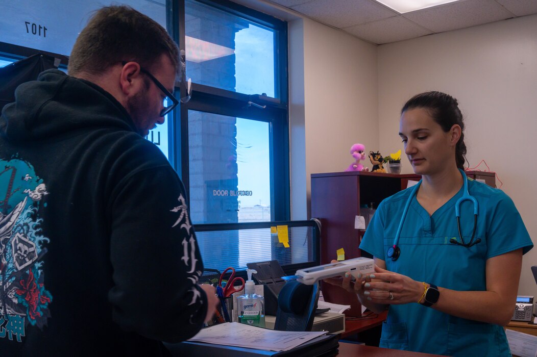 Dr. Rachel Hallman, Luke Air Force Base Veterinary Treatment Facility veterinary medical officer, processes payment from U.S. Air Force Staff Sgt. Nicholas Goodrich, 100th Maintenance Squadron aircraft electrical and environmental systems craftsman, Jan. 13, 2023, at Luke AFB, Arizona.