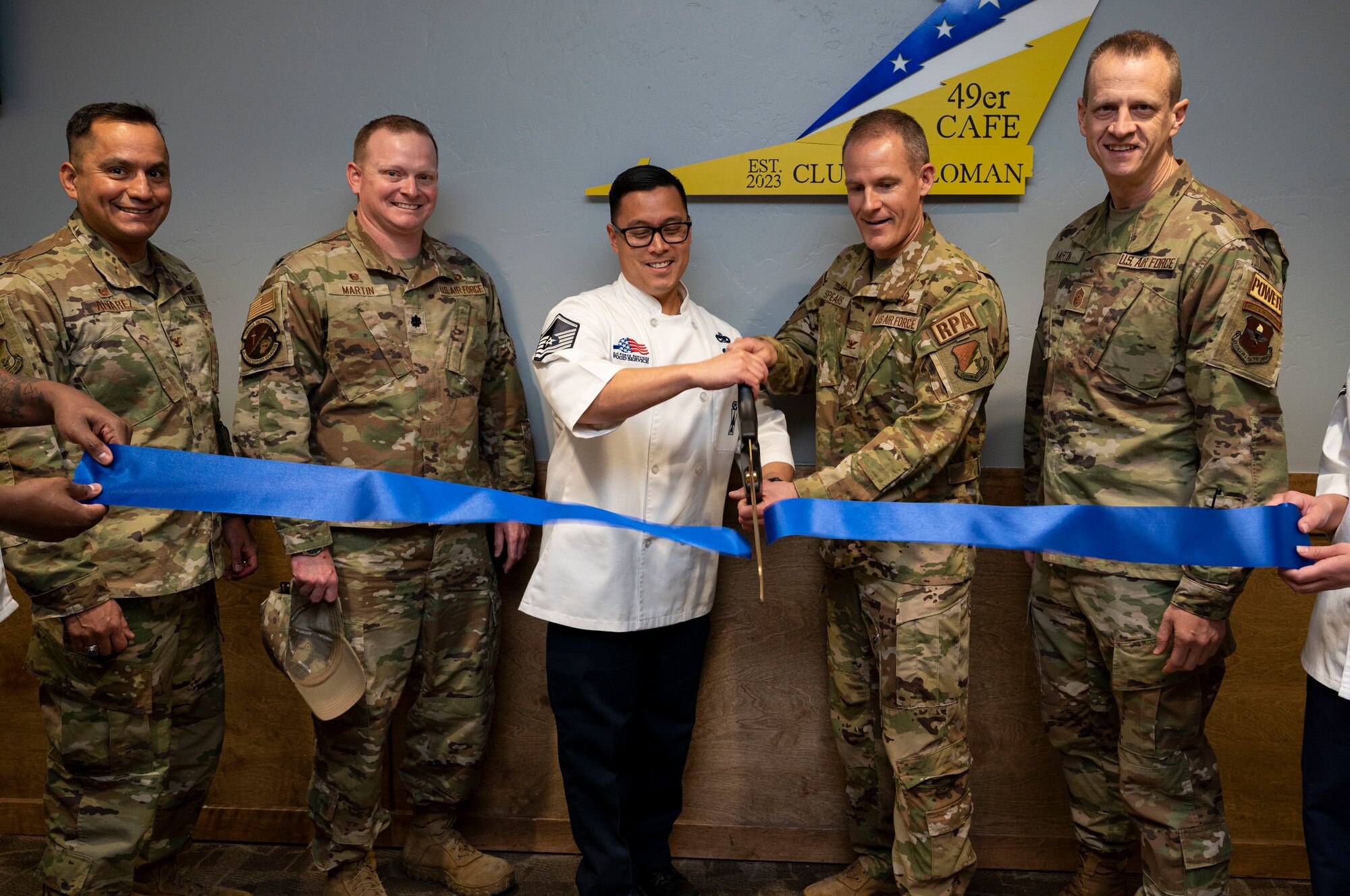 Leadership from the 49th Wing cut a ribbon during the grand opening of the 49er Cafe at Holloman Air Force Base, New Mexico, Feb. 1, 2023.