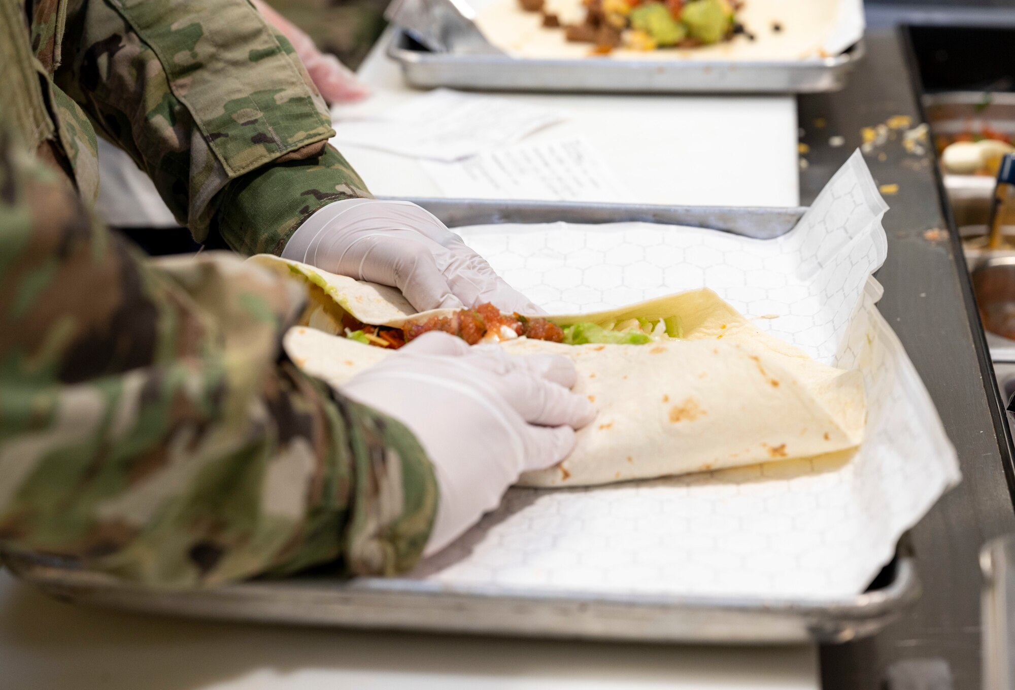 An Airman from the 49th Force Support Squadron wraps a burrito at the 49er Cafe, Holloman Air Force Base, New Mexico, Feb. 1, 2023.