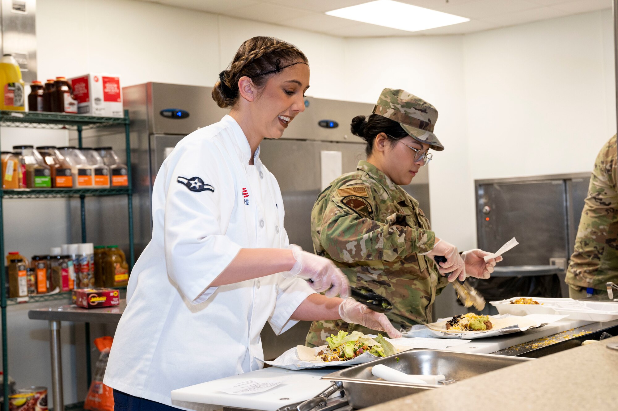 U.S. Air Force Airman Melanie Fry, 49th Force Support Squadron food service apprentice, left, and U.S. Air Force Senior Airman Katrina Nicoli, 49th Force Support Squadron food service journeyman, makes burritos at the 49er Cafe at Holloman Air Force Base, New Mexico, Feb. 1, 2023.