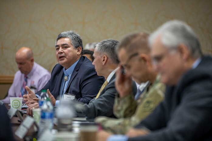 many people seated at table, one speaking