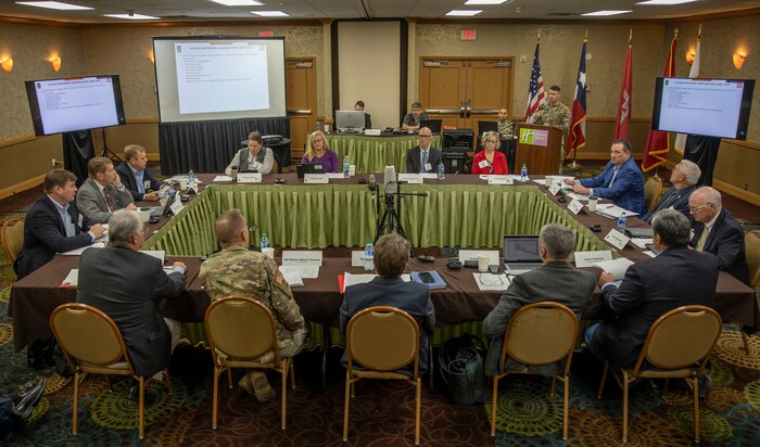 person in front of podium speaks to other people