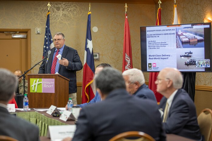 person in front of podium speaks to other people