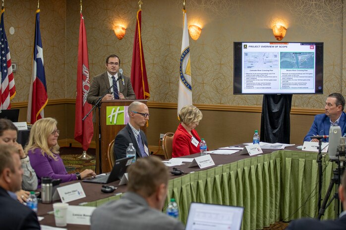 person in front of podium speaks to other people