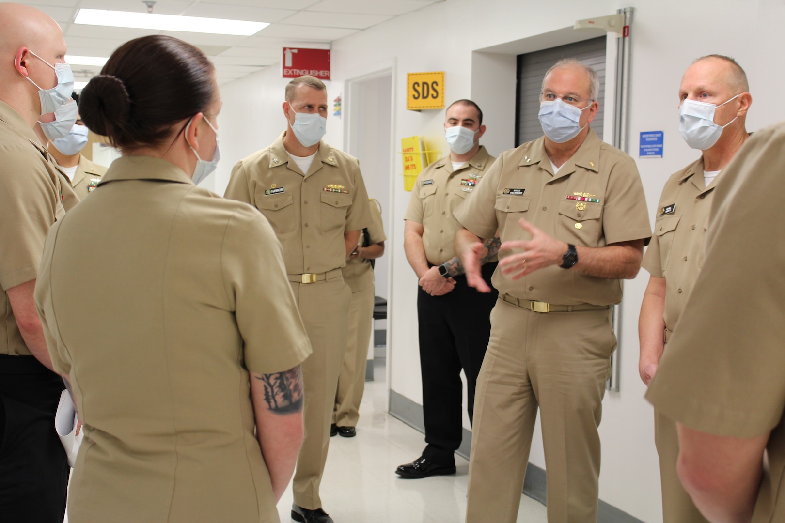 A group of Navy sailors in khaki uniforms talking together.