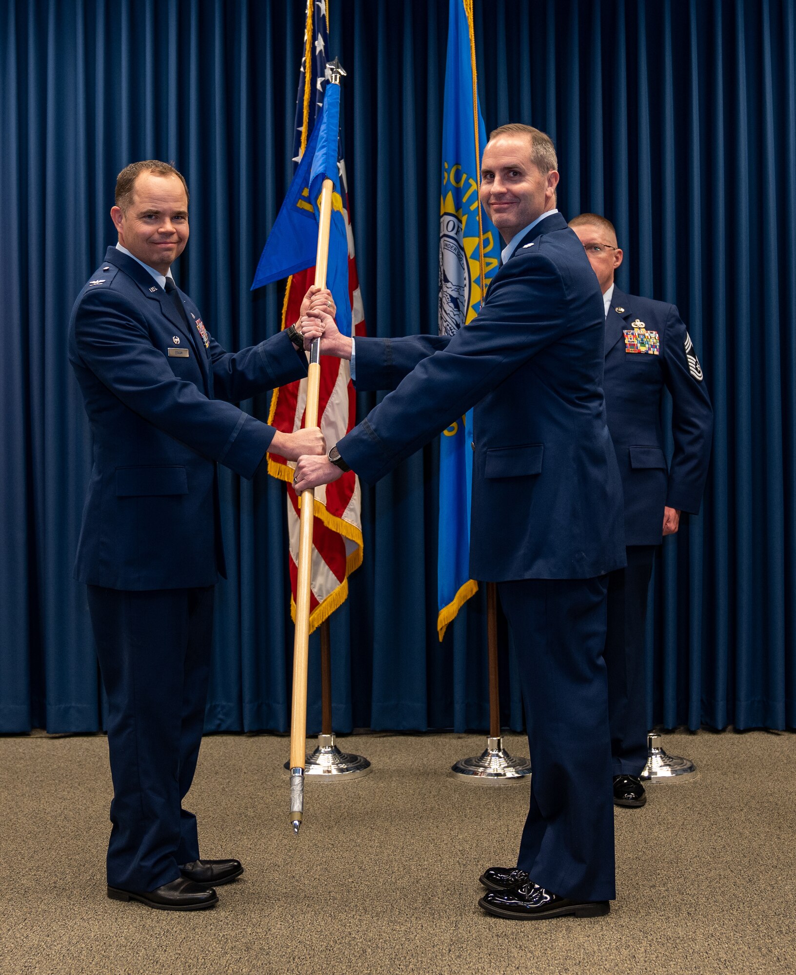 U.S. Air National Guard Lt. Col. Jon Friedman, right, incoming 114th Operations Group commander, receives the group guidon from U.S. Air National Guard Col. Brandon Eskam, left, 114th Fighter Wing commander