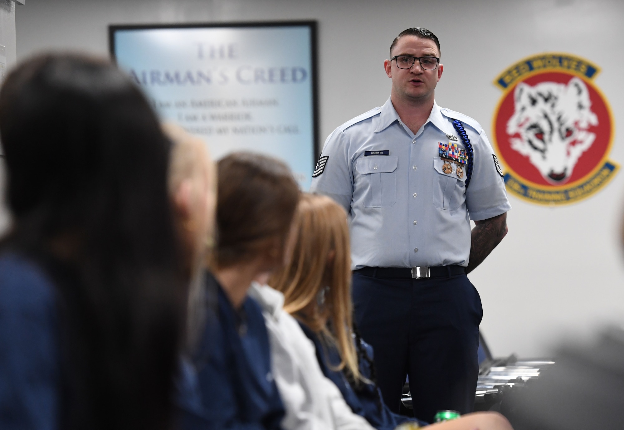 U.S. Air Force Tech. Sgt. James McGrath, 81st Training Support Squadron military training leader, briefs a training Airman's daily schedule to members of the Biloxi Chamber of Commerce Junior Leadership Program inside the Levitow Training Support Facility at Keesler Air Force Base, Mississippi, Jan. 31, 2023.