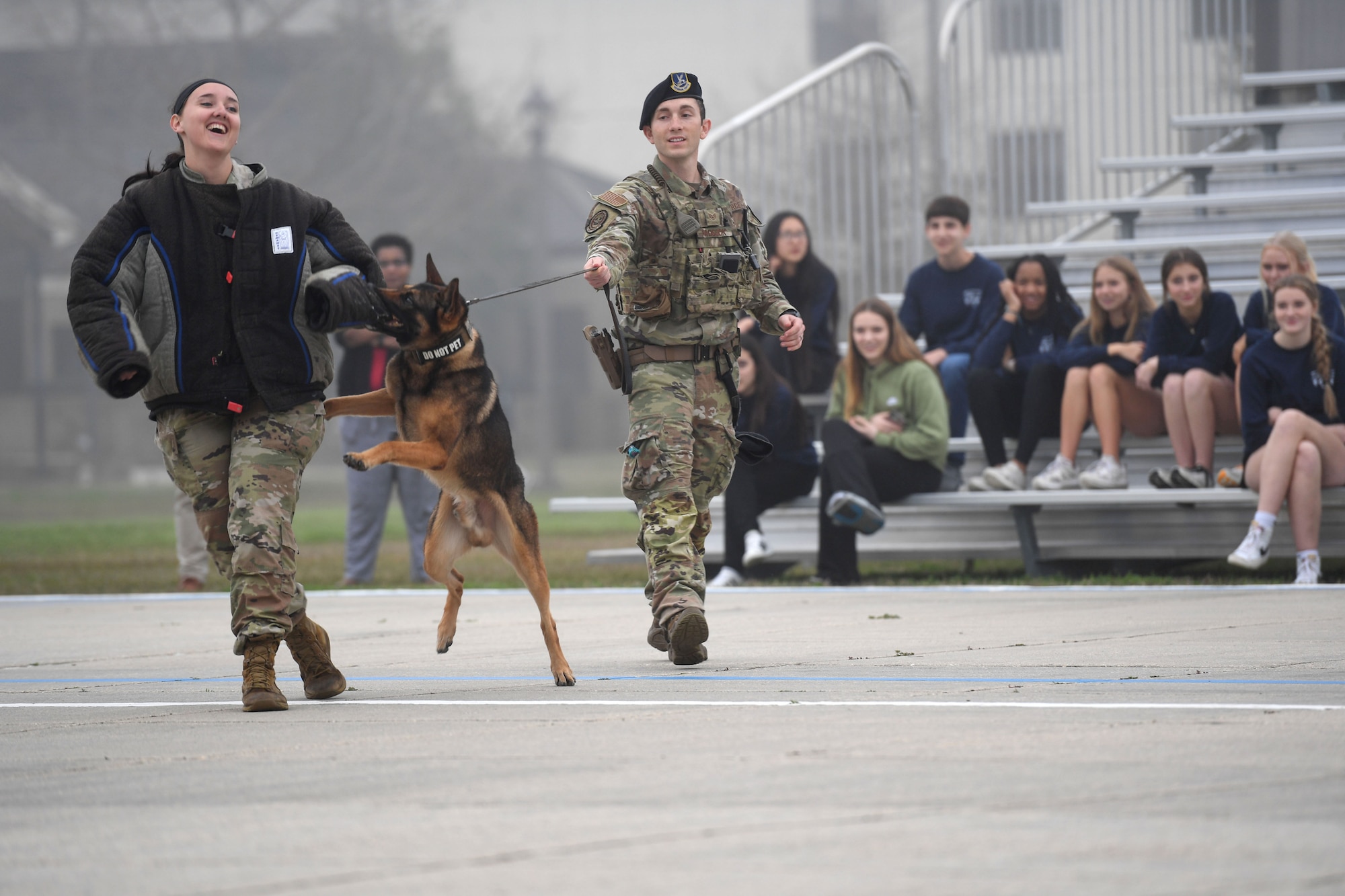 U.S. Air Force Senior Airman Tessa Spare and Staff Sgt. Dustin Hadsock, 81st Security Forces Squadron military working dog handlers, and Rico, 81st SFS military working dog, provide a demonstration to members of the Biloxi Chamber of Commerce Junior Leadership Program on the drill pad at Keesler Air Force Base, Mississippi, Jan. 31, 2023.