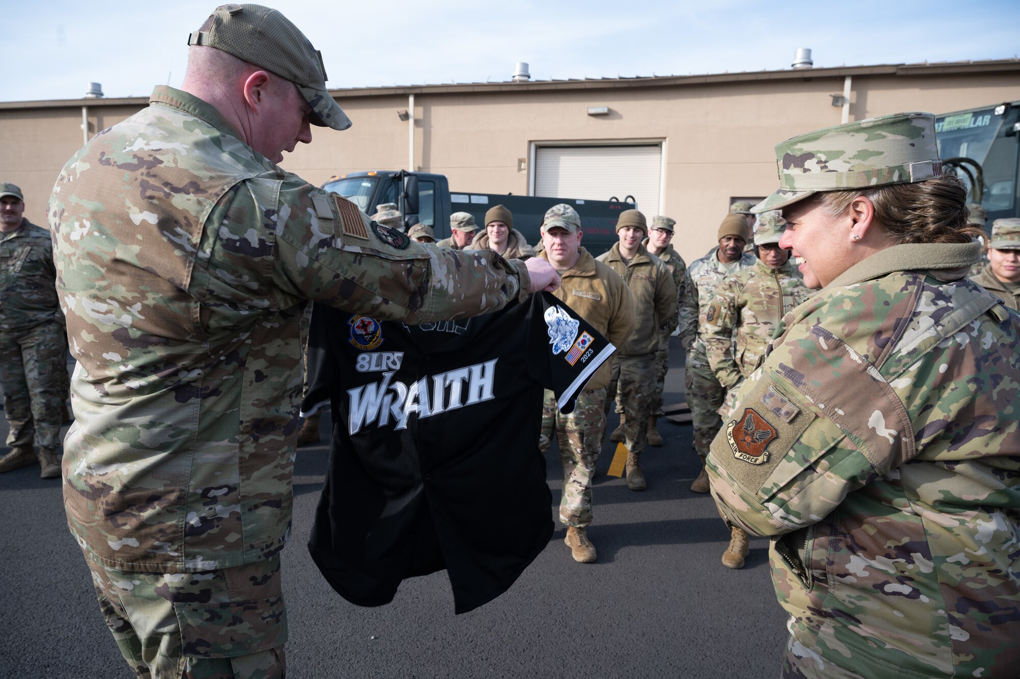 Lt. Col. Travis Rush (left), 8th Logistics Readiness Squadron commander, shows Maj. Gen. Linda S. Hurry, director of logistics, deputy chief of staff for logistics, engineering and force protection, Headquarters Air Force, an 8th LRS morale jersey, at Kunsan Air Base, Republic of Korea, Feb. 1, 2023. Hurry received the “Wraith Nation” jersey as a reminder of the logistics Airmen who operate out of Kunsan and to thank her for listening to their unit’s needs. (U.S. Air Force photo by Staff Sgt. Sadie Colbert)