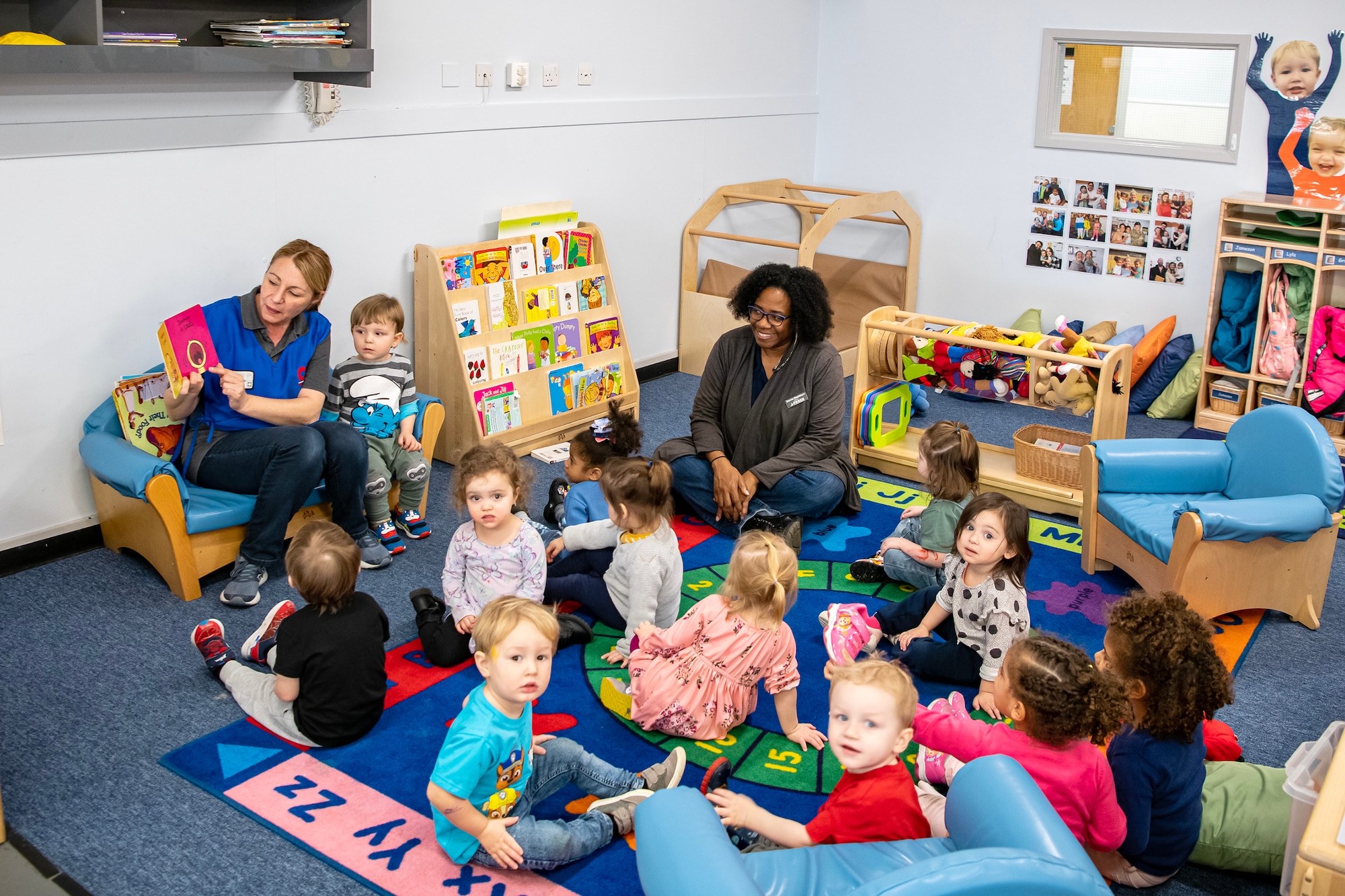 A staff member from the Child Development Center reads a book to children at RAF Alconbury, England, Feb. 2, 2023. The RAFA CDC provides quality child development and services to children and families from all four branches of the Department of Defense. (U.S. Air Force photo by Staff Sgt. Eugene Oliver)