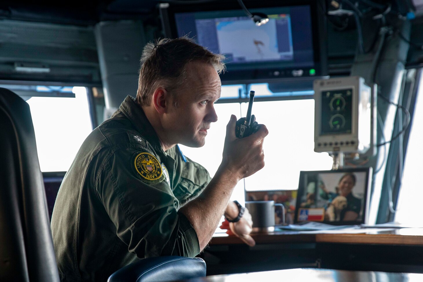 Cmdr. Ryan Conlan, navigation officer of the Nimitz-class aircraft carrier USS George H.W. Bush (CVN 77), relays navigation information into a radio while the ship, along with the embarked staff of Carrier Strike Group (CSG) 10, arrives in Piraeus, Greece, for a scheduled port visit, Feb. 3, 2023.