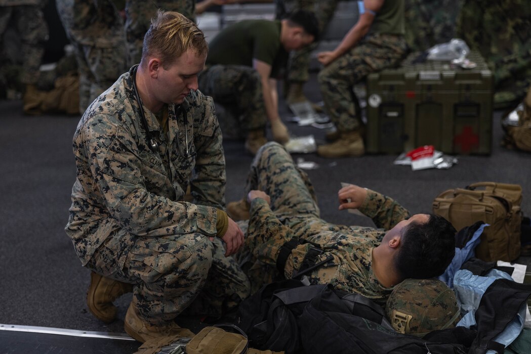U.S. Navy Petty Officer 3rd Class Aidan Clark, a corpsman with 3d Battalion, 4th Marines, provides simulated medical care during a mass casualty drill as part of Fuji Viper 23.2 at Combined Arms Training Center, Camp Fuji, Japan, Jan. 30, 2023. Fuji Viper provides U.S. Marines operating in Japan with realistic training opportunities to exercise combined arms and maintain proficiency, lethality, and readiness. 3/4 is forward deployed in the Indo-Pacific under 4th Marines, 3d Marine Division as part of the Unit Deployment Program. Clark is a native of Olive Branch, MS. (U.S. Marine Corps photo by Cpl. Diana Jimenez)
