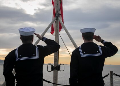 Seaman Dylan Duce, left, and Airman Evan Rowe, both assigned to the Nimitz-class aircraft carrier USS George H.W. Bush (CVN 77), salute the American flag, as the ship along with the embarked staff of Carrier Strike Group (CSG) 10, arrives in Piraeus, Greece, for a scheduled port visit, Feb. 3, 2023.