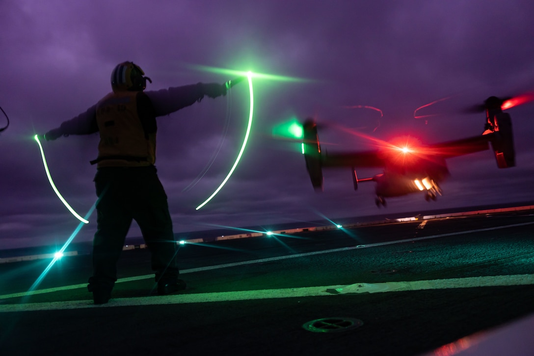 A U.S. Navy Sailor guides a U.S. Marine Corps MV-22 Osprey assigned to Marine Medium Tiltrotor Squadron 162 Reinforced, 26th Marine Expeditionary Unit, while conducting deck landing qualifications aboard the San Antonio-class amphibious transport dock ship USS Mesa Verde during Amphibious Squadron/MEU Integrated Training, Feb. 1, 2023. Pilots with the 26th MEU conducted deck landing qualifications to maintain readiness in preparation for their upcoming deployment.
