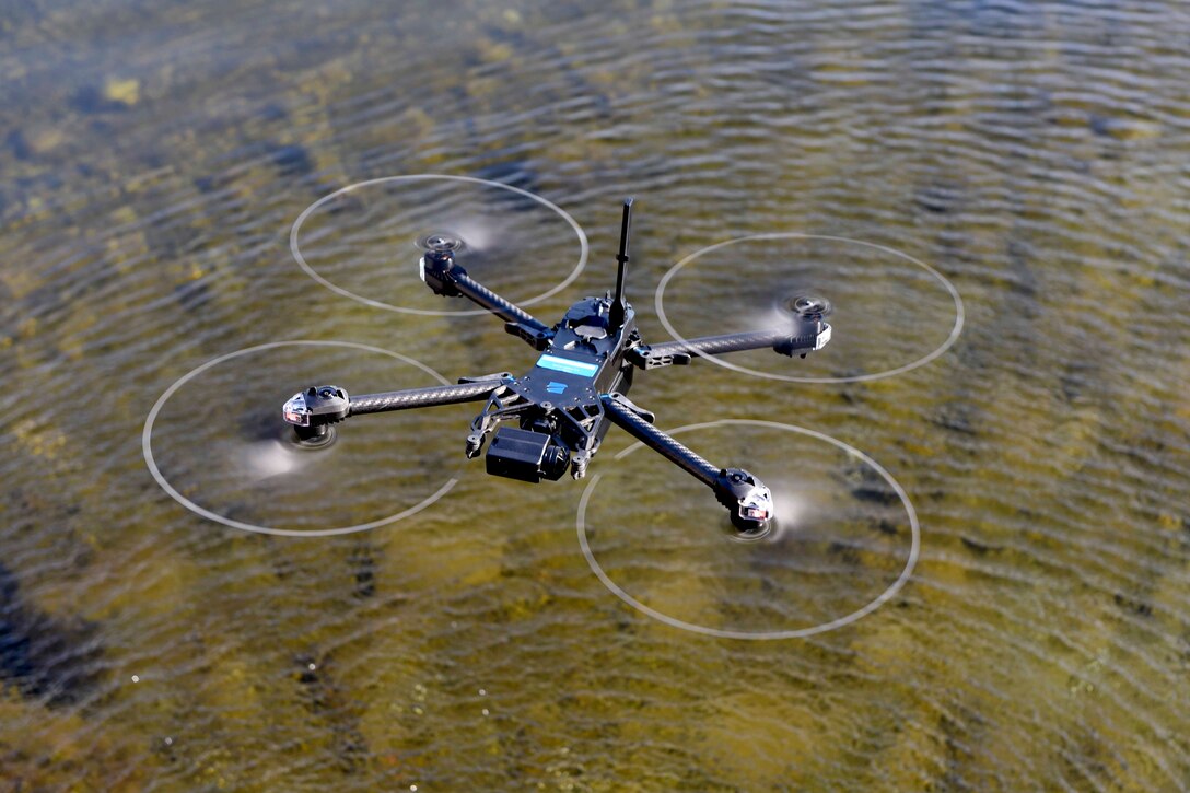 An unmanned aircraft system hovers over shallow waters.