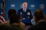 A man in uniform stands behind a podium.