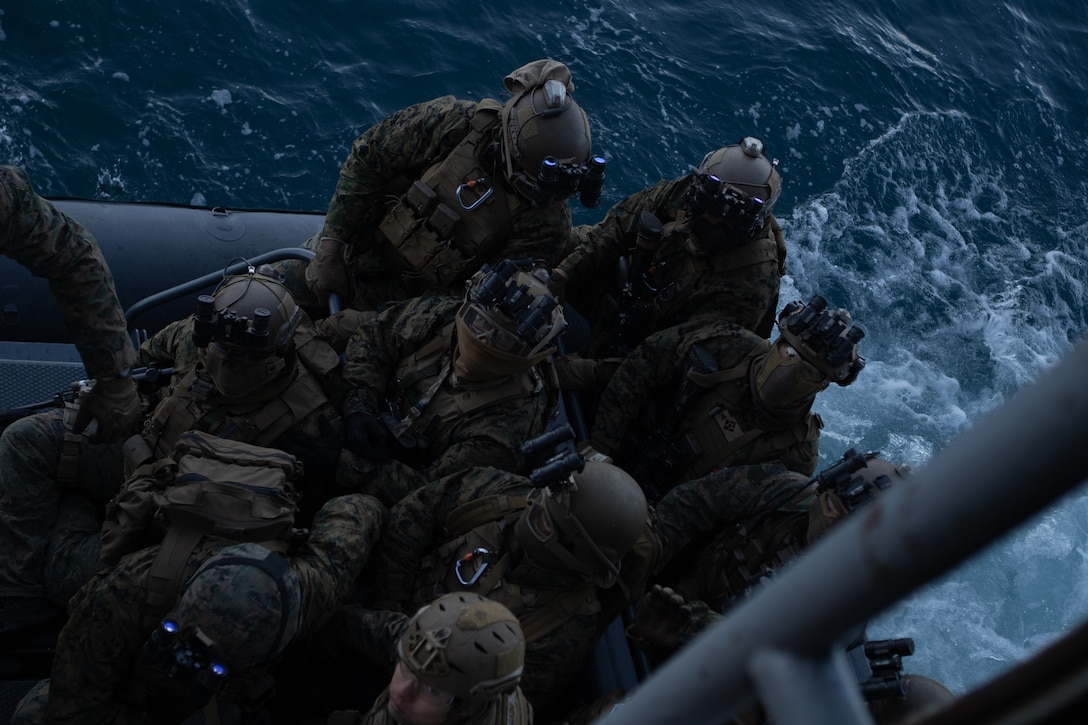 U.S. Marines with Battalion Landing Team 1/6 and Maritime Special Purpose Force, 26th Marine Expeditionary Unit (MEU), climb down from the USS Mesa Verde (LPD 19) onto rigid inflatable boats during a visit, board, search and seizure (VBSS) during PHIBRON/MEU Integration Training (PMINT) while at sea, Jan. 27, 2023. Visit, board, search, and seizure operations are a set of tactics, techniques, and procedures for all missions requiring a target vessel to be visited or boarded. PMINT serves as an opportunity to strengthen integration between the 26th Marine Expeditionary Unit and Amphibious Squadron Group 8’s battle staffs and training to core MAGTF mission essential tasks with capabilities organic to a forward-deployed Amphibious Ready Group/MEU. (U.S. Marine Corps photo by Cpl. Michele Clarke)