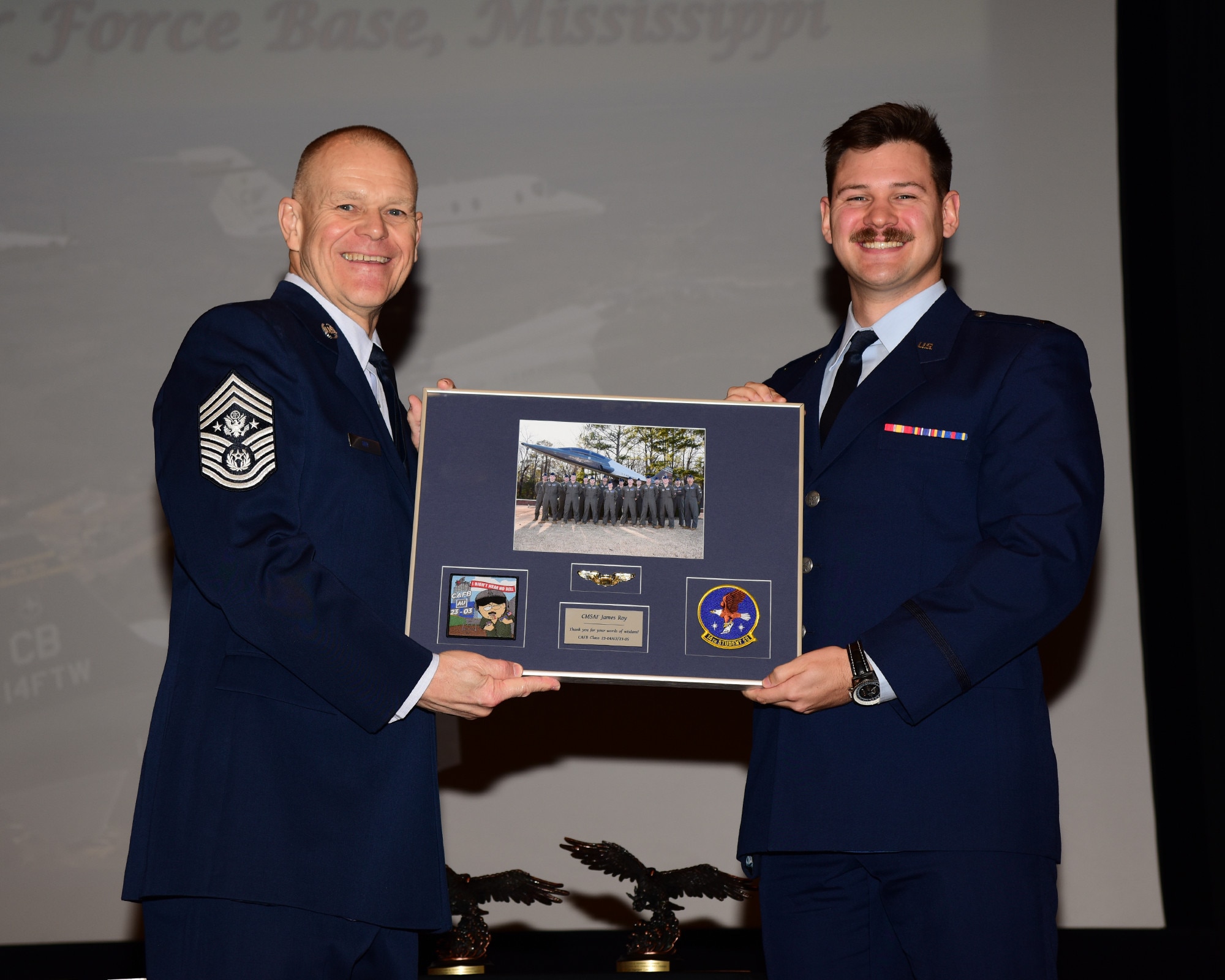 Chief Master Sergeant of the Air Force #16 (retired), James A. Roy, receives a gift from Undergraduate Pilot Training classes 23-04AU and 23-05 during their graduation ceremony. Roy is a former Command Chief at CAFB and returned to attend several events the base is hosting this week. (U.S. Air Force photo by Melissa Duncan-Doublin)