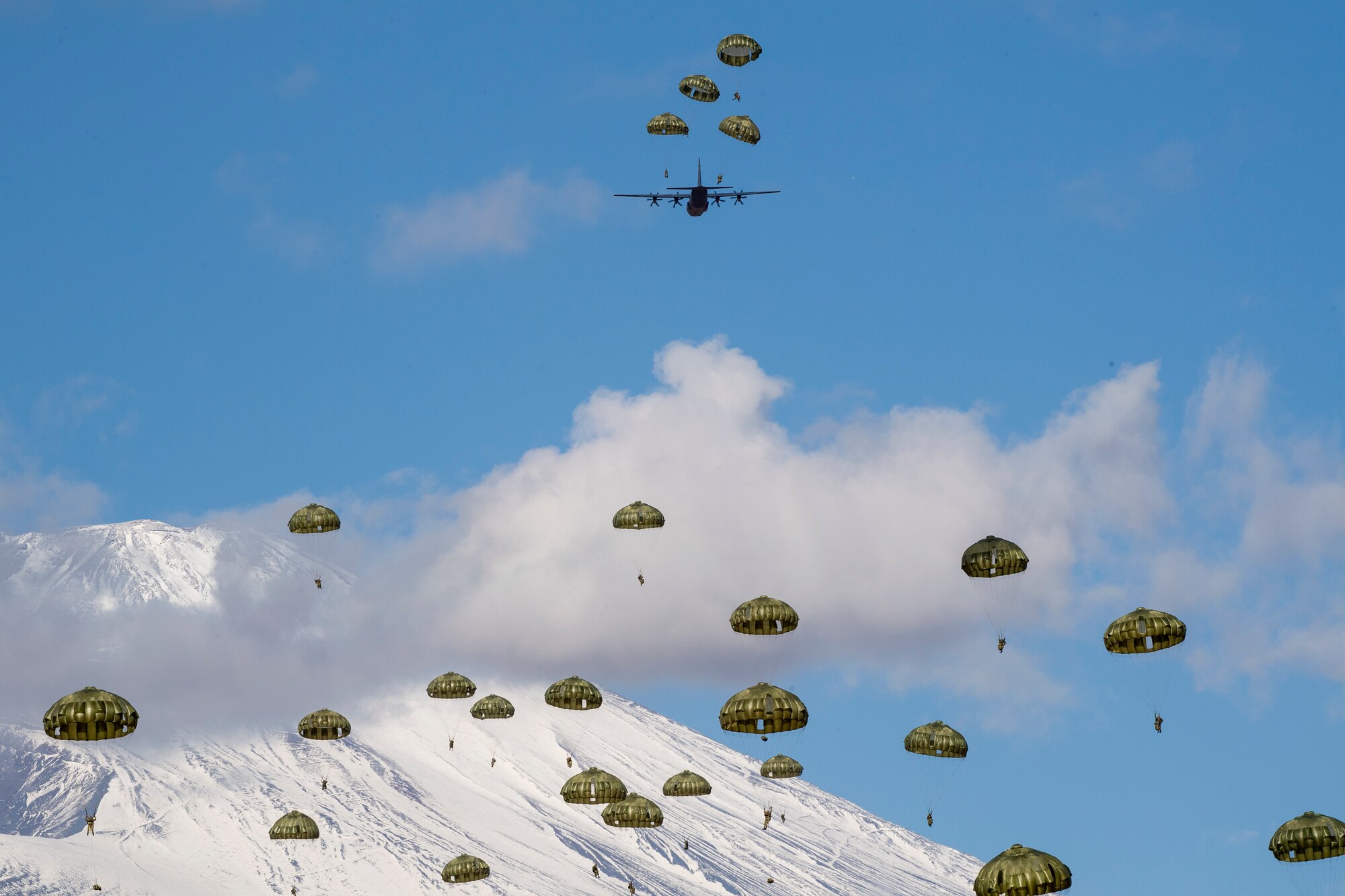 Japan Ground Self-Defense Force paratroopers assigned to the 1st Airborne Brigade descend from a U.S. Air Force C-130J Super Hercules assigned to the 36th Airlift Squadron over JGSDF East Fuji Maneuver Area, Japan, during Airborne 23, Jan. 31, 2023. 300 JGSDF paratroopers performed a static-line jump from Nine U.S. Air Force C-130J’s, showcasing the strategic importance of engaging in joint airborne operations. (U.S. Air Force photo by Yasuo Osakabe)