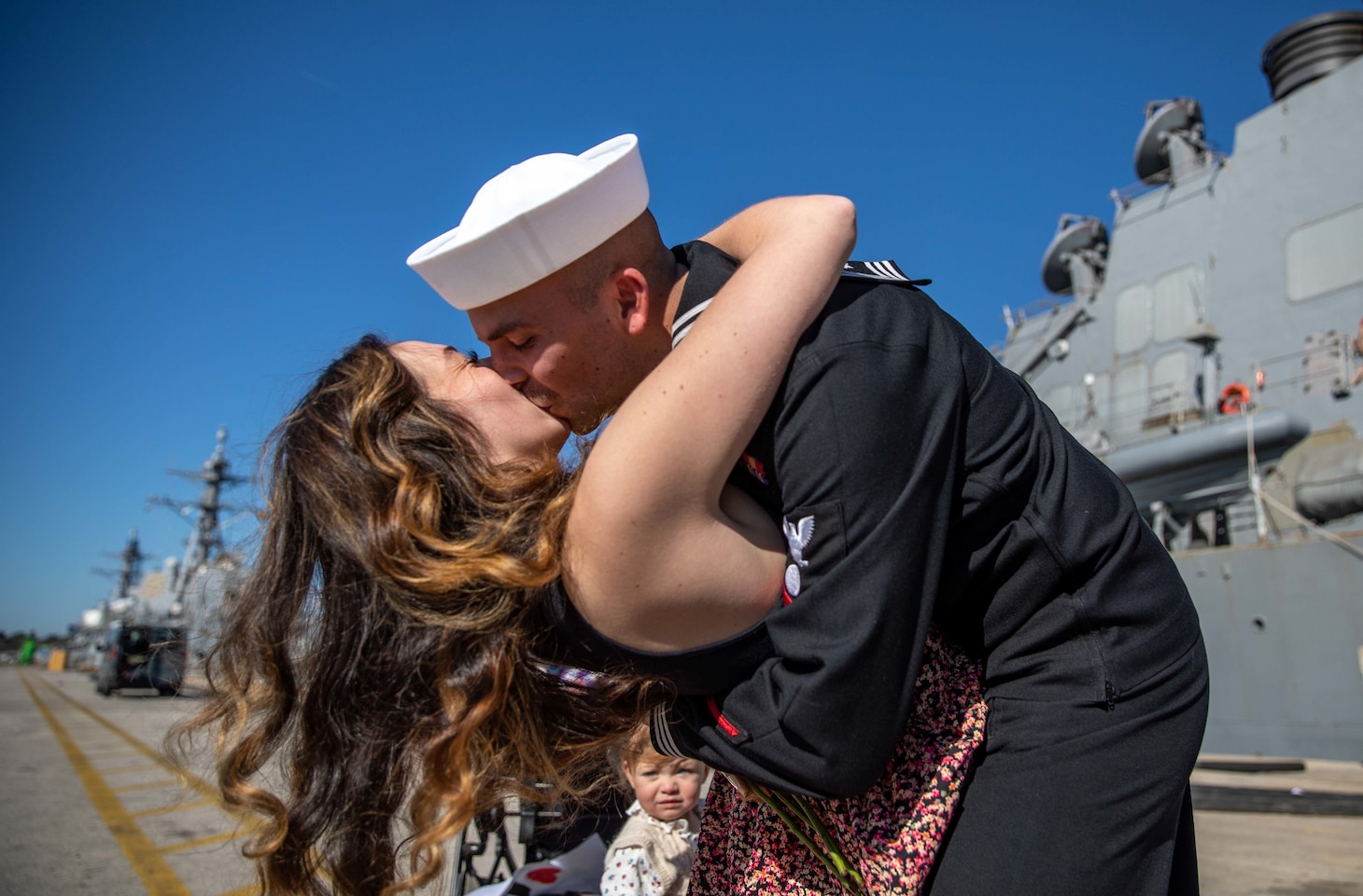 Electrician’s Mate 3rd Class Adam Fisher, right, greets his spouse with the traditional first kiss after returning from patrol aboard the Arleigh Burke-class guided-missile destroyer USS Roosevelt (DDG 80), Feb. 4, 2023.