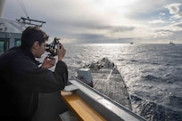 Quartermaster 3rd Class Charles Piloni, assigned to the Arleigh Burke-class guided-missile destroyer USS Nitze (DDG 94),  uses a sextant to get the bearing of the Italian Navy Alpino-class frégate européenne multi-mission frigate ITS Alpino (F 594), Jan. 11, 2023.