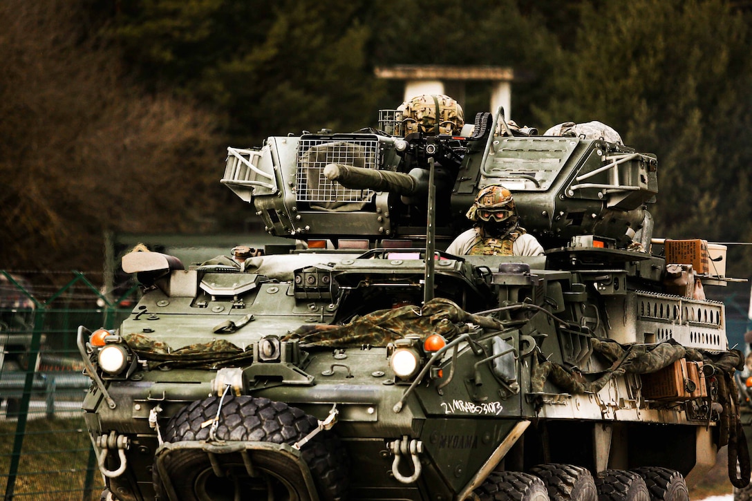 A soldier in a tank participates in a convoy during a training mission.