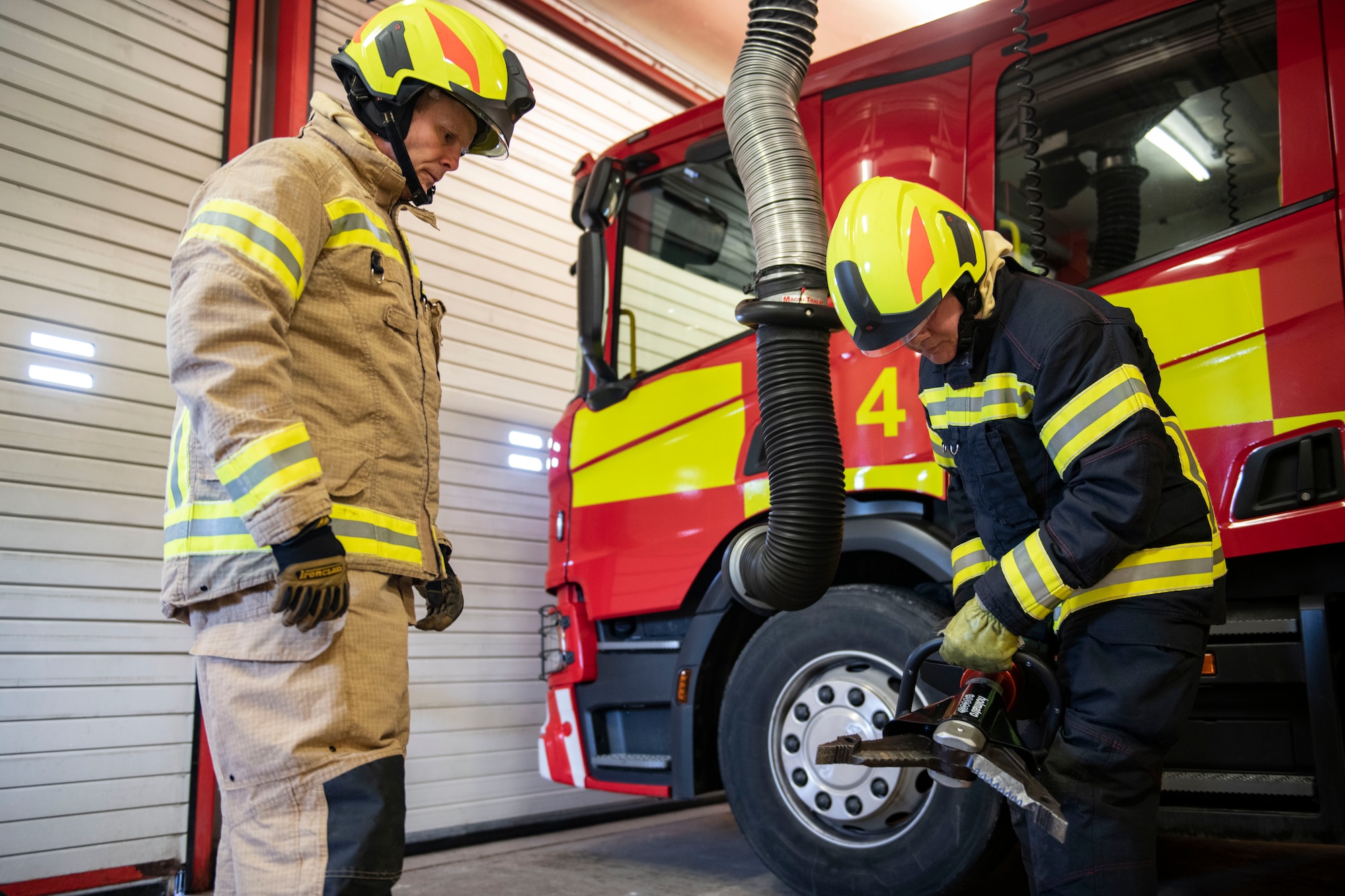 Mark Bell, 421st Air Base Squadron firefighter, left, and Allen Hanton, 421st ABS firefighter, check a piece of equipment at RAF Menwith Hill, England, Jan. 30, 2023. This department had just won the USAFE small fire department of the year and fire prevention program of the year. (U.S. Air Force photo by Senior Airman Jason W. Cochran)