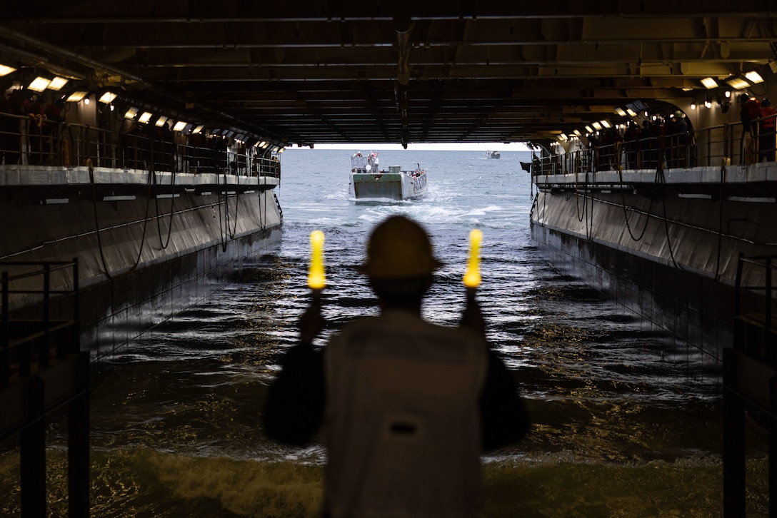 U.S. Navy Petty Officer 2nd Class Clayton Britton, a Bargersville, Indiana native and boatswain’s mate assigned to the Wasp-Class Amphibious Assault Ship USS Bataan (LHD 5), guides a U.S. Marine Corps Landing Craft Utility while underway during Amphibious Squadron/Marine Expeditionary Unit (MEU) Integrated Training, Jan. 23, 2023. PMINT is the first at-sea period in the intermediate stage of the MEU’s Pre-deployment Training Program; it aims to increase interoperability and build relationships between Marines and Sailors.