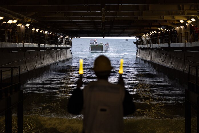 U.S. Navy Petty Officer 2nd Class Clayton Britton, a Bargersville, Indiana native and boatswain’s mate assigned to the Wasp-Class Amphibious Assault Ship USS Bataan (LHD 5), guides a U.S. Marine Corps Landing Craft Utility while underway during Amphibious Squadron/Marine Expeditionary Unit (MEU) Integrated Training, Jan. 23, 2023. PMINT is the first at-sea period in the intermediate stage of the MEU’s Pre-deployment Training Program; it aims to increase interoperability and build relationships between Marines and Sailors.