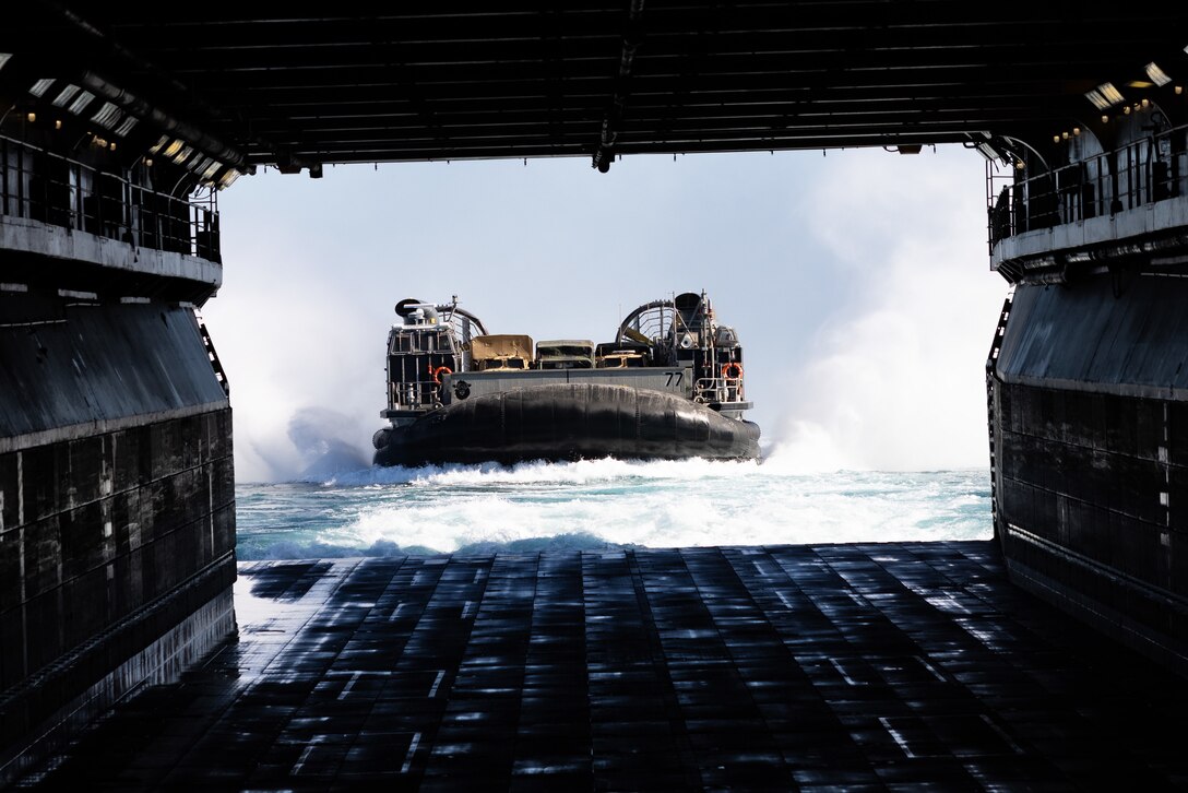 A U.S. Navy Landing Craft Air-Cushioned prepares to board the Wasp-Class Amphibious Assault Ship USS Bataan (LHD 5) while underway during Amphibious Squadron/MEU Integrated Training (PMINT), Jan. 23, 2023. PMINT is the first at-sea period in the intermediate stage of the 26th MEU’s Pre-deployment Training Program; it aims to increase interoperability and build relationships between Marines and Sailors.