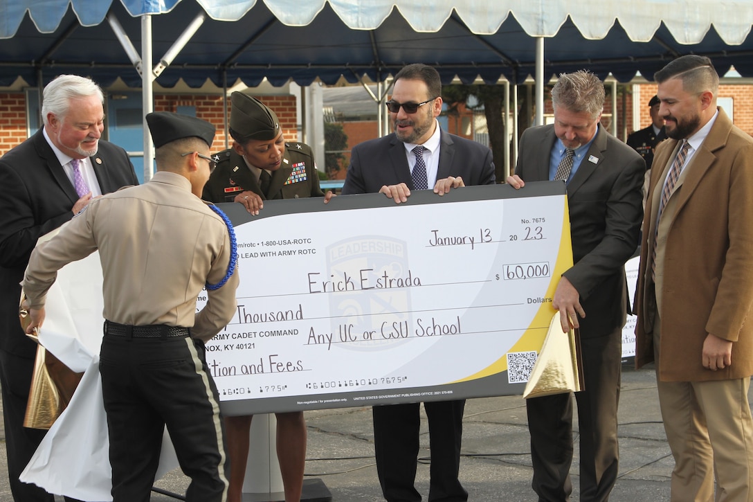 Southeast Academy High School student Erick Estrada, second from left, tears off a cover revealing $50,000 in college scholarship funds Jan. 13 in Norwalk, California.